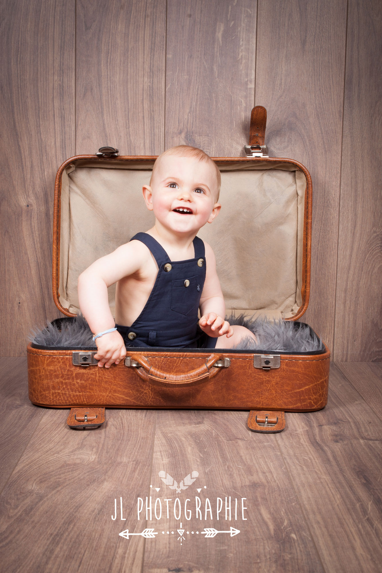 Photographie d'un bébé assis dans une valise