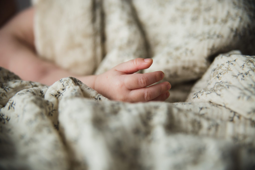 Shooting photo nouveau né en studio d’une main de bébé dans l’Oise