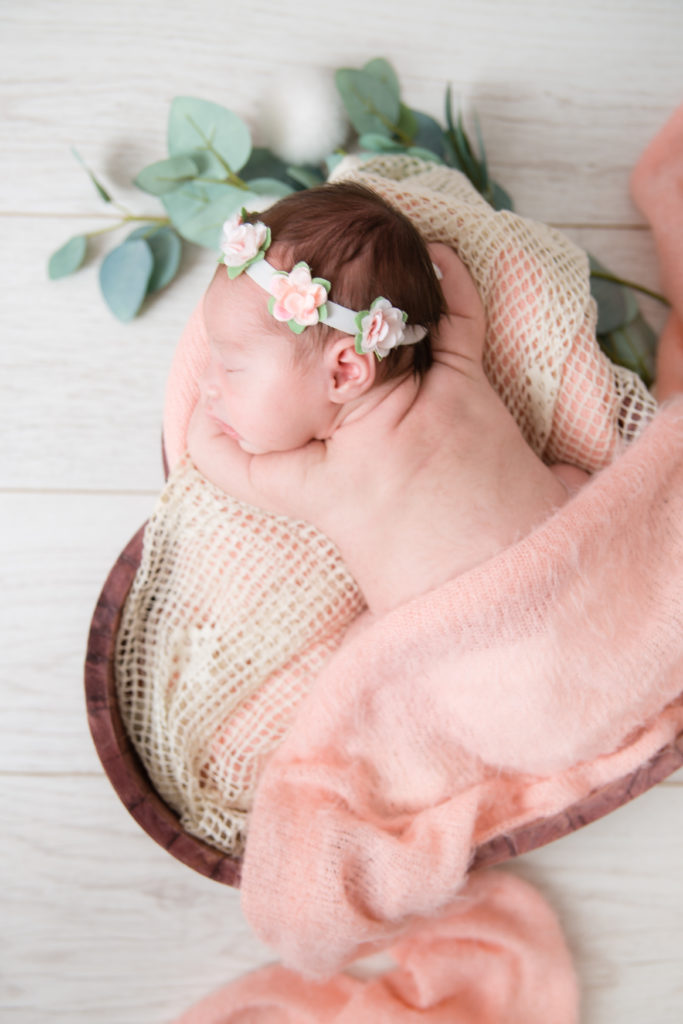 Séance photo nouveau né fille en studio dans l’Oise positionnée dans un coeur en bois