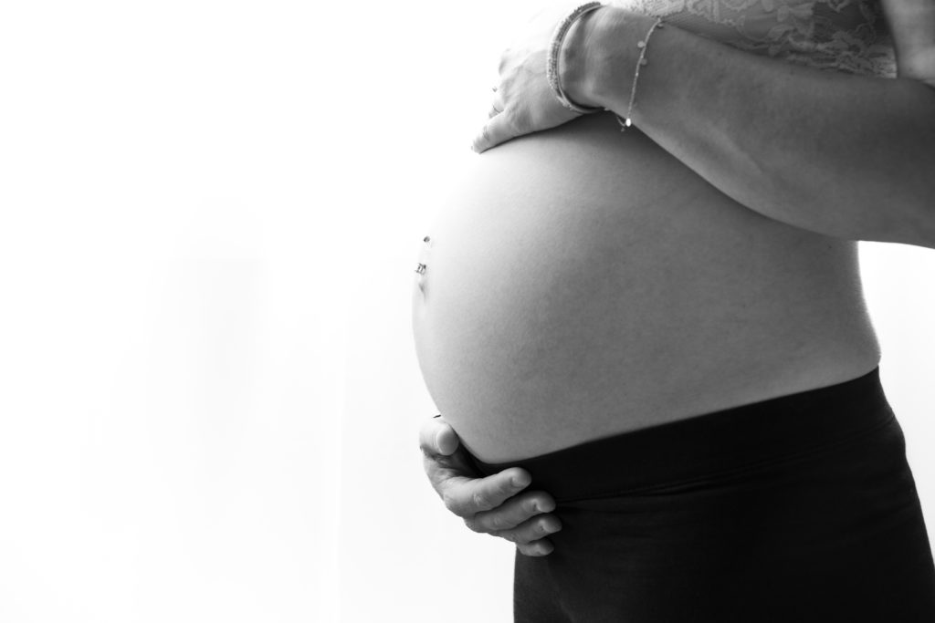 Photographie de grossesse ventre de femme enceinte en noir et blanc