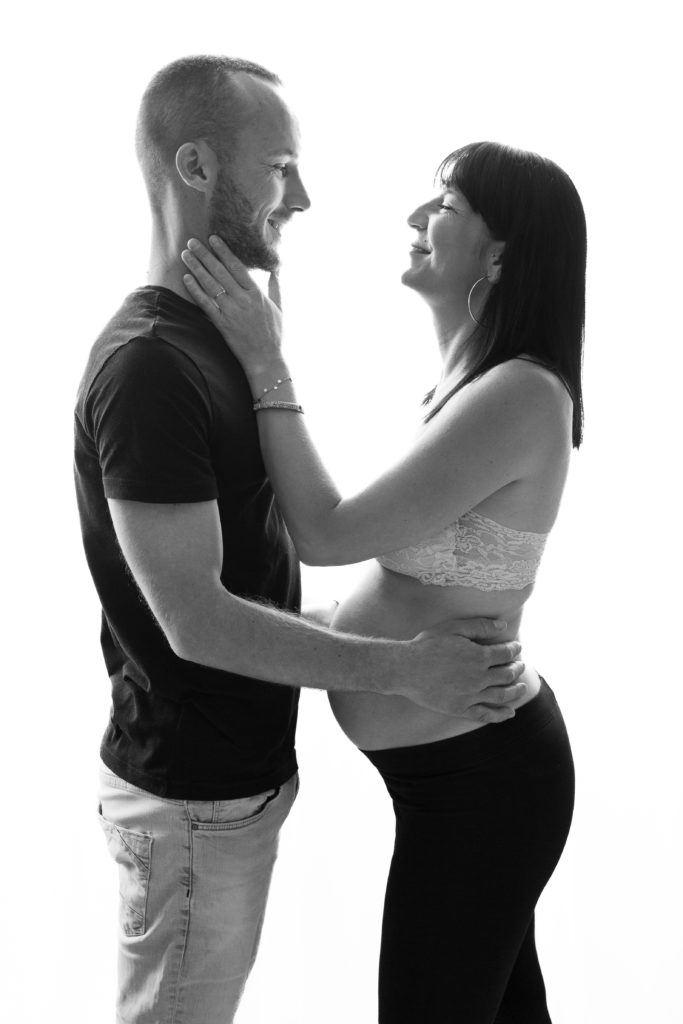 Photographie de grossesse en couple en noir et blanc qui se regardent