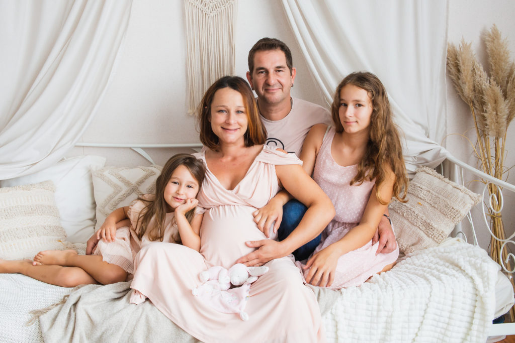 Shooting photo grossesse en studio en famille assis dans un decors bohème
