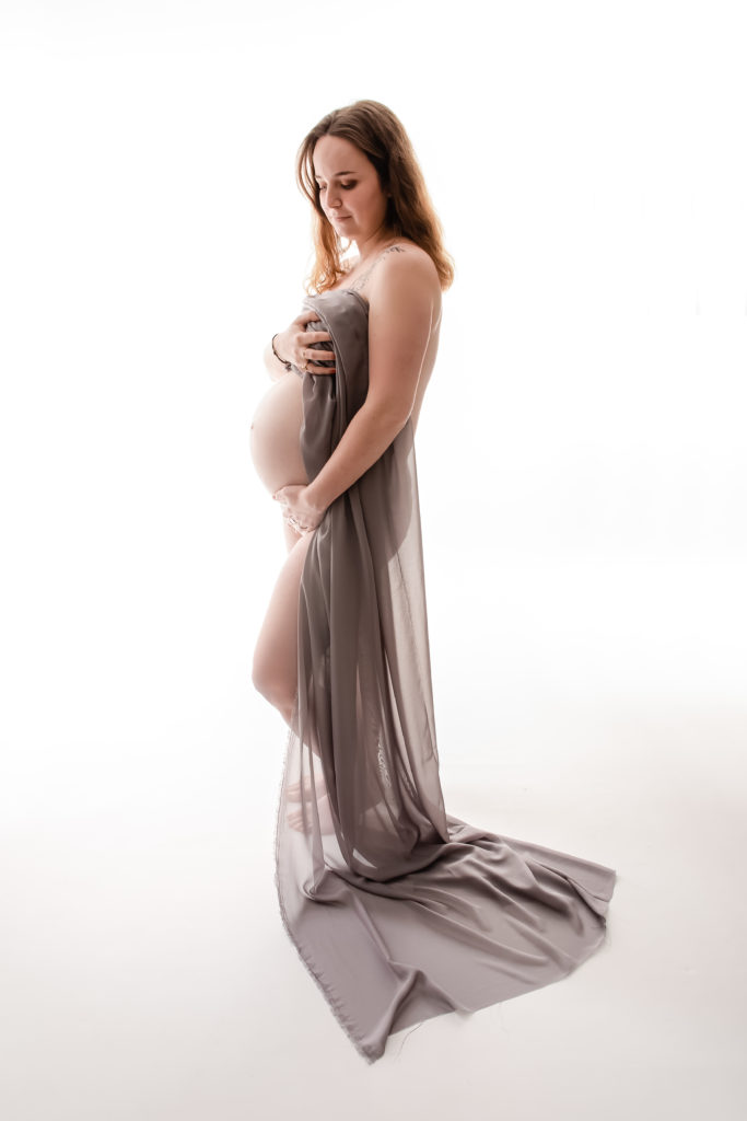 Séance photo grossesse en studio femme enceinte avec voilage