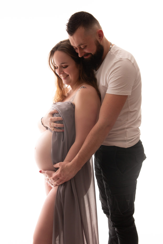 Séance photo grossesse en studio femme enceinte avec voilage