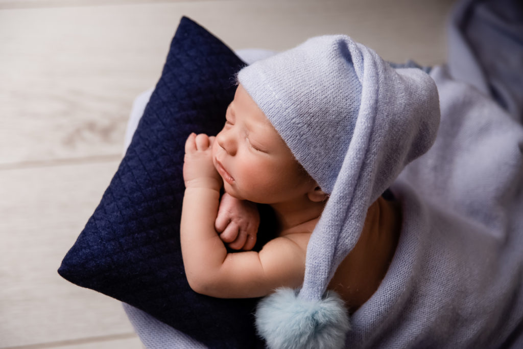 Séance photo nouveau né garçon en studio dans l’Oise positionnée sur dans une boite avec bonnet