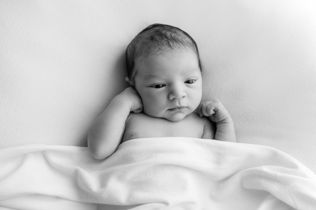 Séance photo nouveau né fille posée sur une couverture beige