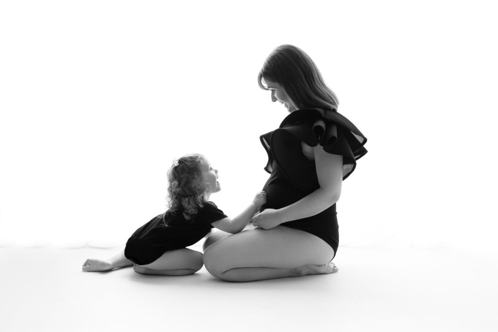 Séance photo grossesse en studio femme enceinte et petite fille avec body noir