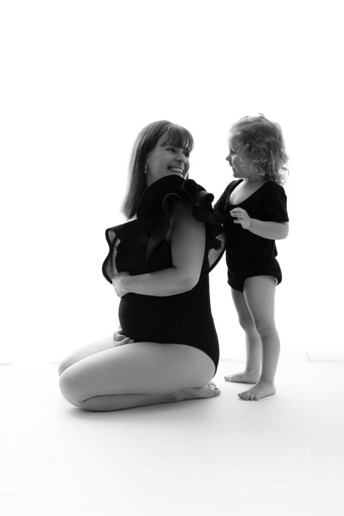 Séance photo grossesse en studio femme enceinte et petite fille avec body noir