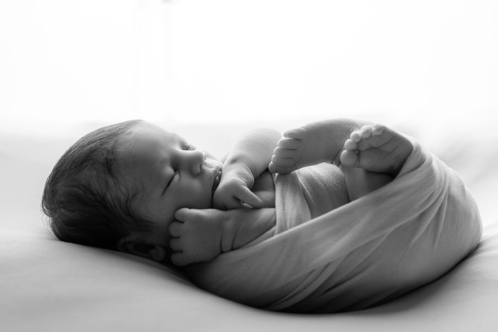 Séance photo nouveau né garçon posée sur une couverture beige