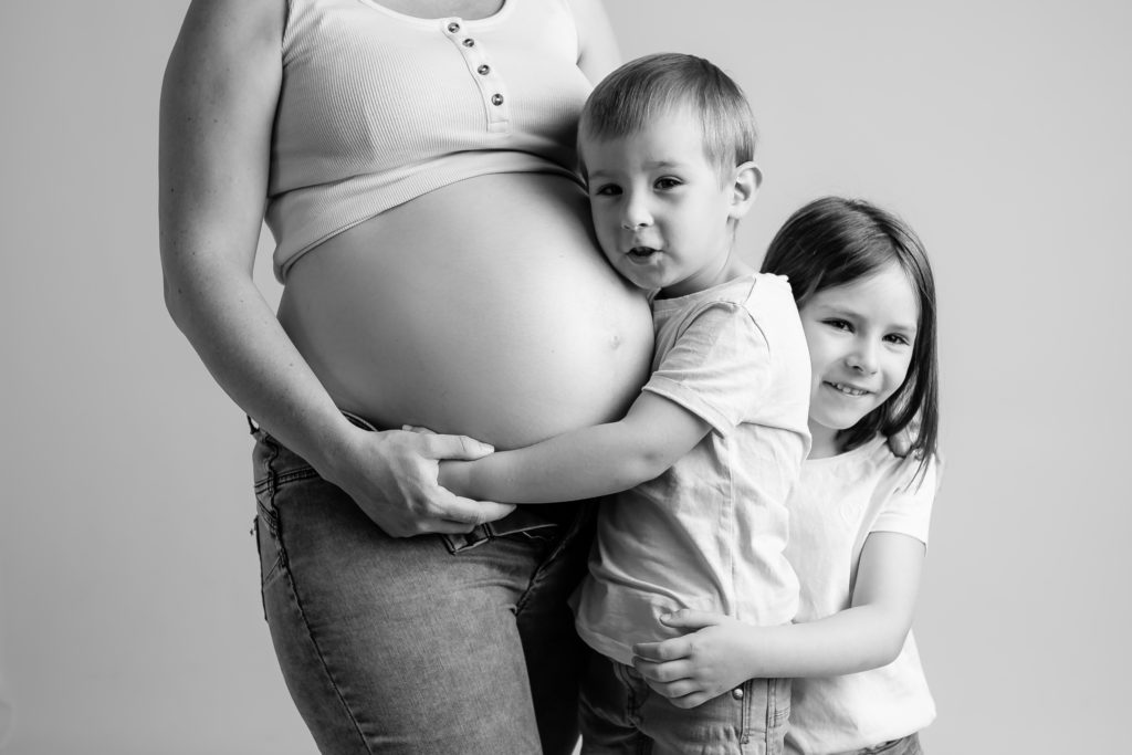 Séance photo grossesse en studio femme enceinte en noir et blanc et en famille
