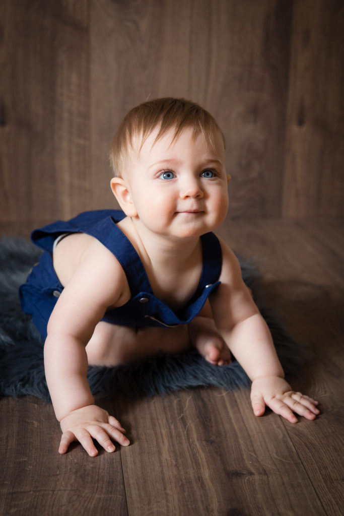 Séance photo bébé sur un fond en bois