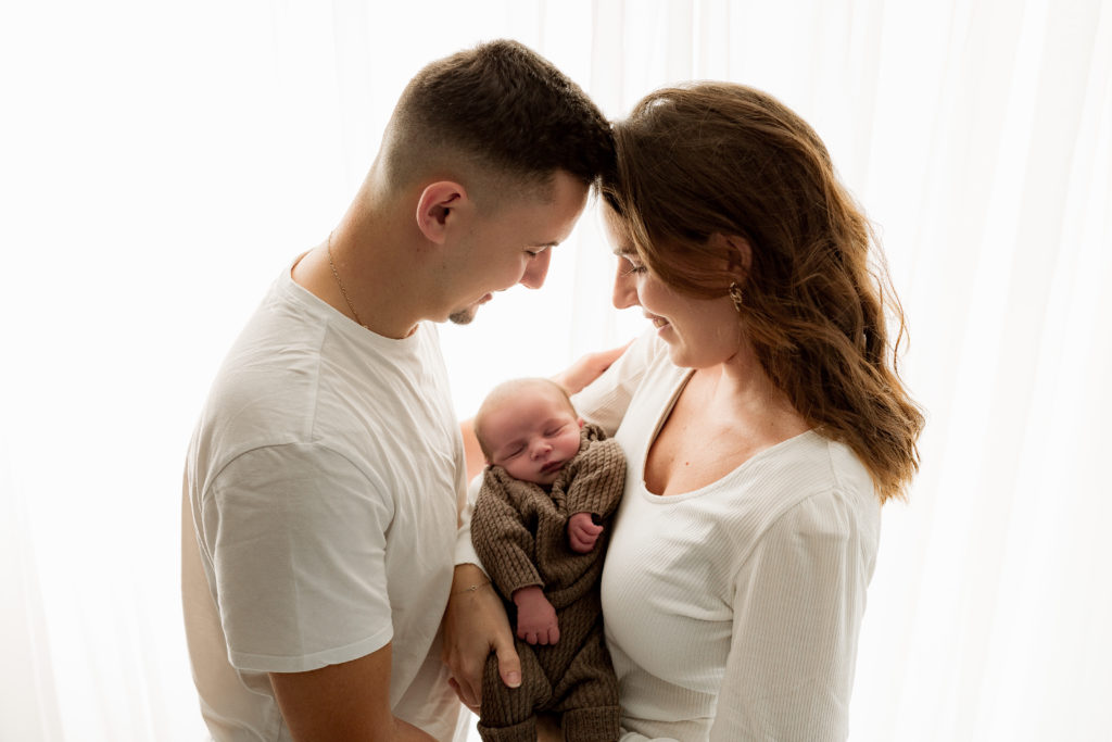 Séance photo nouveau-né sur fond blanc avec les parents