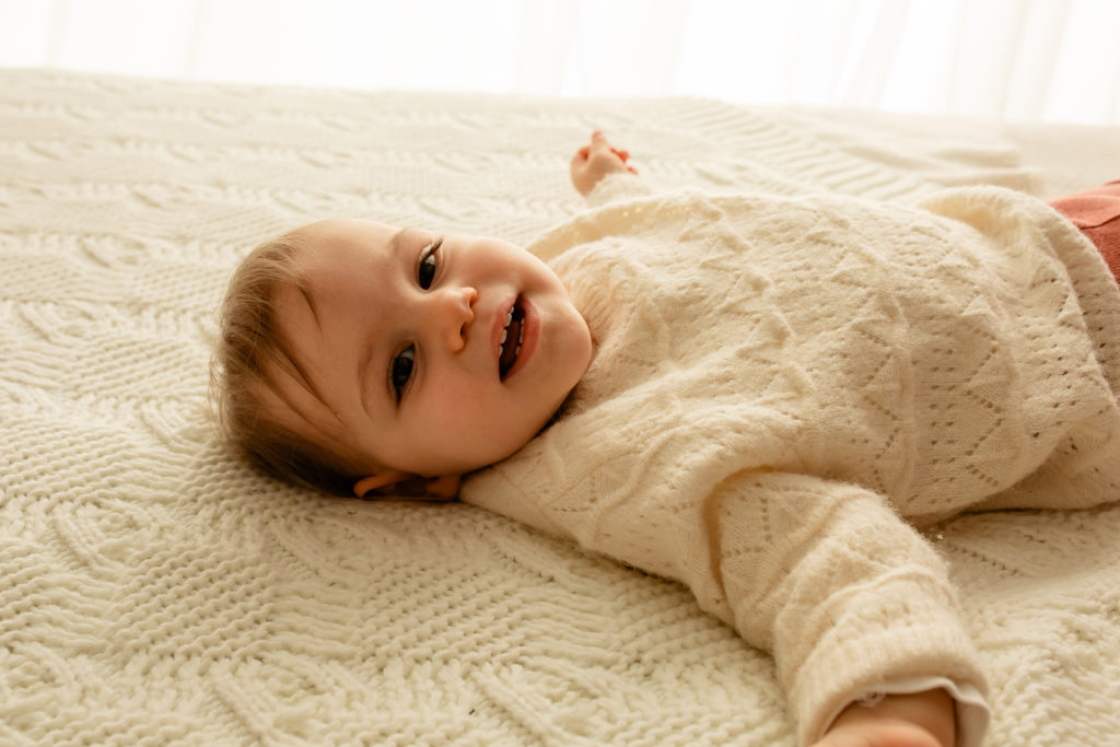 Séance photo de bébé en studio sur un lit décor bohème