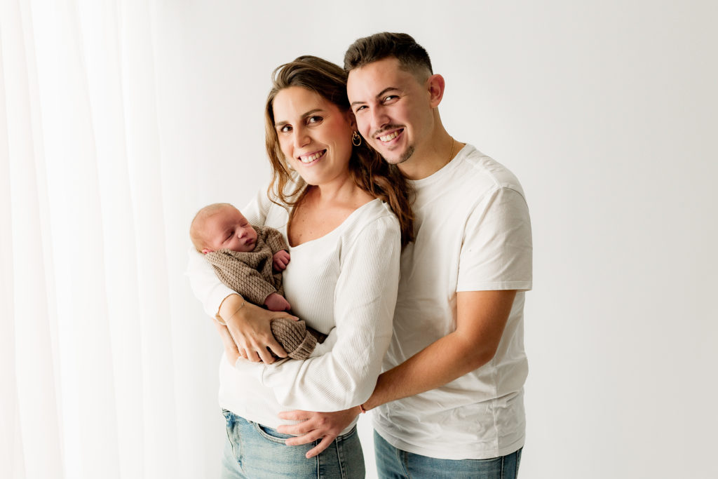 Séance photo nouveau-né sur fond blanc avec les parents