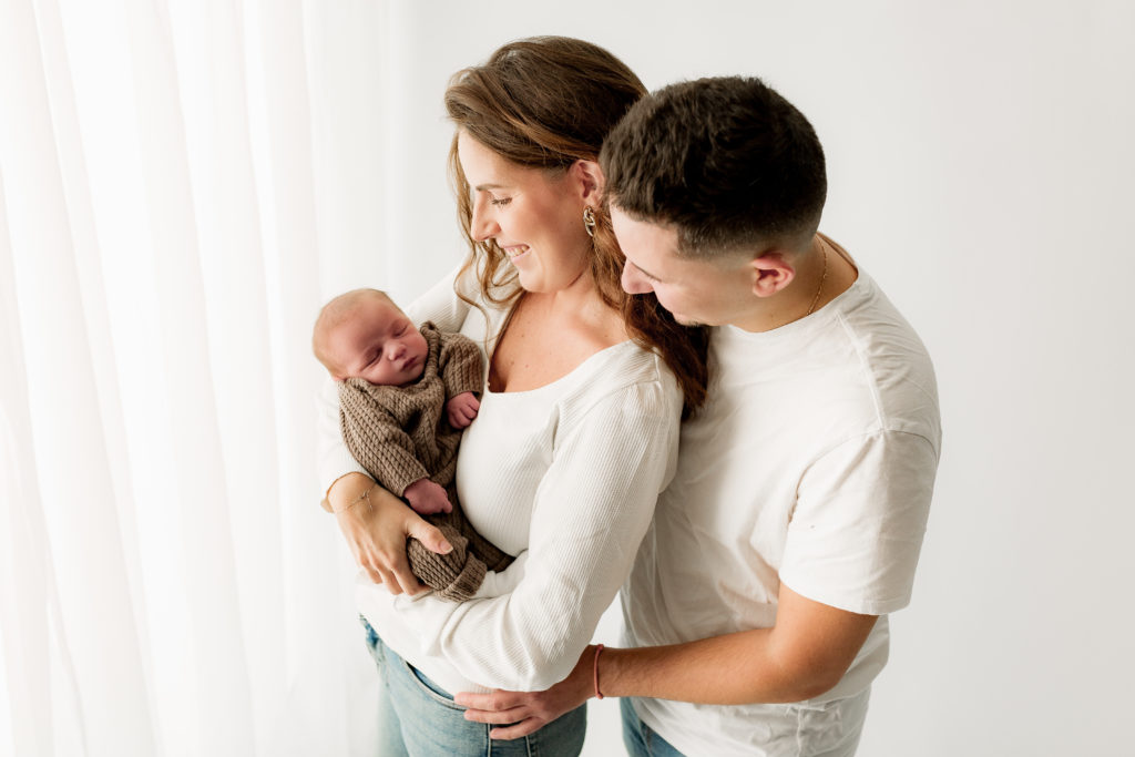 Séance photo nouveau-né sur fond blanc avec les parents