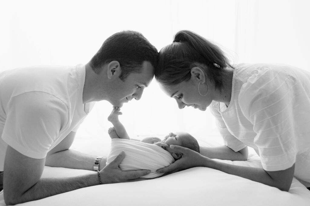Séance photo nouveau-né en lumière naturelle, bébé paisible et capturé dans un cadre chaleureux.