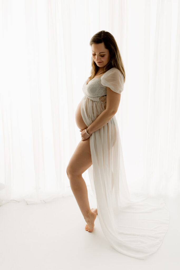 Photo de grossesse en lumière douce, séance photo en studio pour immortaliser ce moment précieux.